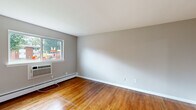 Located at 45 Birch St in Kingston, NY, this one-bedroom, one-bathroom residence offers a well-organized single-floor layout with a functional and comfortable design throughout. Warm-toned hardwood floors run consistently through the living areas, bedroom, and hallway, lending cohesion and a classic appeal to the space.

The layout includes two distinct living areas, providing flexibility for separate lounging and dining arrangements. Both areas are bright, featuring neutral gray walls, baseboard heating, and windows that invite natural light. One living area includes a sliding glass door that opens onto a private deck overlooking lush, mature trees — a standout feature that brings the outdoors in.

The bedroom is generously sized and includes two sliding-door closets for ample storage, along with the same hardwood flooring and a wall-mounted air conditioning unit for year-round comfort.

The kitchen is practical and well-equipped, featuring light gray cabinetry, marble-look countertops, a stainless steel sink, and a window with a pleasant wooded view. A dedicated hallway connects the rooms efficiently, and the bathroom includes a full tub-shower combination with a small window for natural ventilation.

Overall, the space offers a clean, move-in-ready environment with consistent finishes and thoughtful details throughout.
