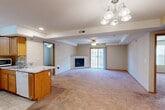 Located at 1016 Haeffele Way in Bloomington, Illinois, this well-appointed 2-bedroom, 2-bathroom single-floor residence offers a thoughtfully designed layout across a comfortable footprint. The open-concept living and dining area serves as the heart of the home, anchored by a corner gas fireplace and sliding glass doors that lead to a private balcony, filling the space with natural light. A ceiling fan and an elegant chandelier complement the tray ceiling detail overhead, adding architectural character to the room.

The kitchen features warm honey-toned cabinetry, granite-look countertops, a peninsula breakfast bar, and tile flooring, flowing seamlessly into the living and dining areas. Appliances including a refrigerator and range are included.

The generously sized primary bedroom offers plush carpeting, a ceiling fan, and a walk-in closet equipped with wire shelving and hanging rods for ample storage. The second bedroom is equally comfortable, with carpeted floors, a ceiling fan, and a window providing natural light. Both bathrooms are finished with granite-topped vanities, wood cabinetry, and tile flooring, with one featuring a full tub-shower combination.

Additional highlights include six closets throughout, a dedicated laundry area, a utility room, and consistent warm-toned carpet and neutral wall colors that create a cohesive, inviting ambiance throughout the home.
