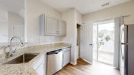 This thoughtfully designed three-floor residence offers a versatile and functional layout across its multiple levels. The ground floor includes an attached garage with a full-sized door and epoxy-coated concrete flooring, providing secure and convenient parking or additional storage space.

The main living level features an open-concept design where the kitchen flows seamlessly into the living area. The kitchen is well-equipped with granite countertops, light gray cabinetry, a classic white subway tile backsplash, and a full suite of stainless steel appliances including a gas range, built-in microwave, and dishwasher. A door off the kitchen leads to an outdoor deck. The adjoining living room is bright and inviting, with light hardwood-style flooring, crown molding, a ceiling fan, a fireplace, and multiple windows that allow generous natural light.

The upper floors house the bedrooms, which feature plush carpeting, ceiling fans, and windows with neighborhood views. Bathrooms throughout the home are finished consistently with granite-topped gray vanities and hardwood-style flooring; one includes a soaking tub with shower combination, while another features a standalone glass-door shower. Carpeted staircases connect all three levels, completing this well-finished multi-level home.