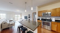 Located at 2950 Clearwater Ln in Waukesha, Wisconsin, this 2-bedroom, 3-bathroom residence offers a well-designed layout that balances functionality and comfort. The open-concept kitchen and living area serves as the heart of the home, featuring warm honey-toned cabinetry, dark granite countertops, and a full suite of stainless steel appliances including a refrigerator, range, microwave, and dishwasher. A large kitchen island with pendant lighting provides additional prep space and casual seating, flowing seamlessly into the bright living area with hardwood flooring and access to a private patio. The spacious primary bedroom is carpeted and includes natural light from well-positioned windows, offering a comfortable and quiet retreat. A second bedroom provides additional versatility. Three bathrooms serve the home, each finished with tile flooring, wood-toned vanities, and white countertops, offering clean and practical design. A carpeted staircase with a wood handrail connects the levels, while multiple closets throughout the home ensure ample storage. The overall aesthetic is modern and understated, with neutral tones and quality finishes creating a cohesive and welcoming atmosphere throughout.