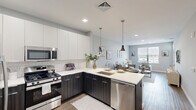 Located at 110 Woodcrest Rd in Cherry Hill, NJ, this well-appointed one-bedroom, one-bathroom residence offers a thoughtfully designed open-concept layout across a single floor. The contemporary kitchen is a standout feature, showcasing two-tone cabinetry with dark lower cabinets and crisp white upper cabinets, a white quartz countertop, classic subway tile backsplash, and a full suite of stainless steel appliances including a gas range, built-in microwave, dishwasher, and French door refrigerator. Pendant lighting over the peninsula adds a refined touch, and the kitchen flows seamlessly into the combined dining and living area, which benefits from natural light through large windows. The living room is a comfortable, neutral-toned space with wood-look flooring that extends throughout. A welcoming entryway with a transom-lit front door opens into the main living area. The bedroom offers a ceiling fan, a generous closet, and a window with outdoor views, creating a calm retreat. The bathroom features a soaking tub with a full subway tile surround. The space combines modern finishes with a clean, neutral palette for a fresh and functional living environment.