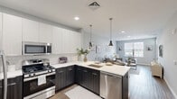 Located at 110 Woodcrest Rd in Cherry Hill, NJ, this well-appointed one-bedroom, one-bathroom residence offers a thoughtfully designed open-concept layout across a single floor. The contemporary kitchen is a standout feature, showcasing two-tone cabinetry with dark lower cabinets and crisp white upper cabinets, a white quartz countertop, classic subway tile backsplash, and a full suite of stainless steel appliances including a gas range, built-in microwave, dishwasher, and French door refrigerator. Pendant lighting over the peninsula adds a refined touch, and the kitchen flows seamlessly into the combined dining and living area, which benefits from natural light through large windows. The living room is a comfortable, neutral-toned space with wood-look flooring that extends throughout. A welcoming entryway with a transom-lit front door opens into the main living area. The bedroom offers a ceiling fan, a generous closet, and a window with outdoor views, creating a calm retreat. The bathroom features a soaking tub with a full subway tile surround. The space combines modern finishes with a clean, neutral palette for a fresh and functional living environment.
