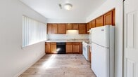 Located at 609-623 Flint Rd in Brighton, MI, this single-floor, 2-bedroom unit offers a straightforward and functional layout designed for comfortable everyday living. The kitchen is well-equipped with warm honey-toned wood cabinetry, light granite-style countertops, and full appliances including a gas range, dishwasher, and refrigerator. Natural light streams in through a large window with vertical blinds, illuminating the wood-look vinyl plank flooring that flows throughout the main living and kitchen areas. The living area is open and bright, with large windows dressed in vertical blinds that allow ample natural light and views of the surrounding greenery. A connecting hallway links the main living spaces to the two bedrooms. The primary bedroom is generously sized, featuring plush carpeting, a window with outdoor views, and a closet with paneled doors. The second bedroom is equally carpeted and bright, with its own window and access to a closet. The unit maintains a clean, neutral color palette of white and soft gray throughout, providing a versatile backdrop for any décor style. Wood-look flooring in common areas and carpet in the bedrooms add both practicality and comfort to this well-organized Brighton residence.