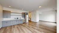 Located at 2132 Stokes Blvd in Cleveland's University Circle area, this one-bedroom, one-bathroom unit offers a thoughtfully designed modern layout. Light-toned wood-style flooring runs throughout, creating a bright and cohesive feel across every room.

The open-concept kitchen and living area forms the heart of the unit. The kitchen is outfitted with sleek gray cabinetry, white subway tile backsplash, white quartz countertops, stainless steel appliances including a refrigerator and dishwasher, and ample upper and lower cabinet storage. The adjacent living area is generously proportioned and bathed in natural light from a large picture window and a sliding glass door that opens to a private balcony with open city views.

The bedroom continues the clean aesthetic with light flooring, a sliding glass door to the balcony, and a dedicated closet with louvered doors. The bathroom features marble-look tile flooring, a gray vanity with white countertop, a large mirror, and matte black hardware and accessories for a contemporary finish. A dedicated laundry area completes the unit's practical offerings.

Throughout, crisp white walls, recessed lighting, and a neutral palette contribute to a clean, modern ambiance well-suited for comfortable urban living.