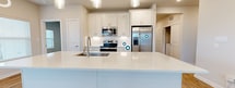 This contemporary 980 square foot apartment in Katy, TX offers a harmonious blend of style and functionality. The open-concept living area is anchored by warm hardwood flooring, creating a seamless flow between the kitchen and living room. Large windows flood the space with natural light, enhancing the airy ambiance.

The gourmet kitchen is a standout feature, boasting sleek white cabinetry, stainless steel appliances, and a generous quartz-topped island. Pendant lighting adds a touch of elegance, while the subway tile backsplash contributes to the modern aesthetic.

The primary bedroom, measuring 150 square feet, provides ample space and is equipped with plush carpeting and large windows. The second bedroom mirrors this comfort, offering versatility for a guest room or home office.

Both bathrooms showcase clean lines with modern fixtures, including a bathtub in one and likely a walk-in shower in the other. The use of large format tiles and neutral tones creates a spa-like atmosphere.

Throughout the apartment, recessed lighting and ceiling fans enhance comfort and ambiance. Two hallways and closets offer practical storage solutions, completing this well-designed living space that balances style with everyday livability.