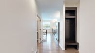 Located at 6201 Johnson Dr in Mission, Kansas, this 1-bedroom, 2-bathroom residence delivers a thoughtfully designed single-floor layout with modern finishes throughout. The open-concept kitchen and living area forms the heart of the home, featuring wood-look flooring, recessed lighting, and generous natural light from multiple windows. The kitchen is outfitted with dark cabinetry, glass-front upper cabinets, stainless steel appliances, a large island with a white countertop, and an undermount sink — combining style with functionality. The living area extends to a private balcony through French doors with a transom window, offering views of the surrounding Mission neighborhood and green treetops beyond. The spacious primary bedroom is finished with plush carpet, a ceiling fan, built-in shelving, and sliding glass doors that open to an additional balcony. The full bathroom features a dual-sink vanity with dark wood cabinetry, tile flooring, a large mirror, and a tiled shower. A second half-bath includes a pedestal sink and neutral-toned walls. A dedicated closet provides organized storage space, completing this well-appointed residence.