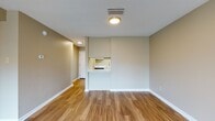 This single-story residence offers a well-organized layout that balances functionality and comfort throughout its various rooms. The galley-style kitchen is equipped with black appliances, including a refrigerator, electric range, and over-the-range microwave, all complemented by crisp white cabinetry and light countertops. Wood-look flooring runs through the kitchen and connects to a pass-through opening that overlooks an adjacent living or dining area, creating a sense of openness between the spaces.

The main living area is generously sized, featuring the same wood-look flooring, a ceiling fan with light fixture, and access to what appears to be a patio or balcony through a sliding door, allowing natural light to fill the space. Neutral beige-toned walls carry throughout the unit, providing a cohesive and understated aesthetic.

The bedrooms are carpeted for added comfort and each features a ceiling fan, natural light from windows, and ample closet space with bifold doors. One bedroom includes a notably expansive double-closet configuration. The bathrooms are finished with wood-look flooring, white vanity cabinetry, and tub-shower combinations, with one bathroom featuring grab bars for added accessibility.