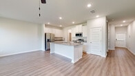 Located at 2920 Florence Dr in Gainesville, GA, this two-story home offers a well-designed layout across two floors, with four bedrooms and four full bathrooms. The main level features an open-concept kitchen and living area finished with light luxury vinyl plank flooring throughout. The kitchen is a standout space, showcasing crisp white shaker cabinetry, granite countertops, a central island with a sink, and a full suite of stainless steel appliances including a French door refrigerator, range, and microwave. Recessed lighting illuminates the space, which flows seamlessly into the living room — a bright, airy area with a ceiling fan and natural light pouring in through multiple windows. The upper floor hosts the primary bedroom suite, a generously sized retreat featuring a tray ceiling, ceiling fan, dual windows with outdoor views, and a private bathroom with granite countertops and a glass-enclosed shower. A spacious walk-in closet with wire shelving provides ample storage. Additional bedrooms are well-proportioned with clean finishes and consistent flooring. Bathrooms feature tub-shower combos and bright, clean white surrounds. A utility room and dedicated hallways complete the functional layout of this move-in ready home.