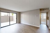 Located in Indio, CA, this single-floor, 2-bedroom, 2-bathroom home offers a thoughtfully designed layout with a clean, neutral aesthetic throughout. The open living and dining area features light wood-style flooring, soft neutral walls, and a sliding glass door that fills the space with natural light and provides direct access to a private patio. A ceiling fan adds comfort to the adjoining area, which flows seamlessly into the kitchen. The kitchen is a standout feature, boasting rich dark wood cabinetry, granite countertops, a tray ceiling with recessed lighting, and a full suite of stainless steel appliances including a refrigerator, range, microwave, and dishwasher. A breakfast bar connects the kitchen to the living space, enhancing the open feel. The bedrooms are carpeted for comfort, each offering a calm retreat with neutral tones and ample natural light. The primary bedroom includes its own closet, and there are three closets throughout the home for generous storage. Both bathrooms are clean and functional, featuring tub/shower combinations with granite-accented vanities. A dedicated laundry area and a hallway complete the well-organized floor plan.