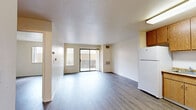 Located at Village Center Dr in Sacramento, CA, this single-floor, one-bedroom, one-bathroom residence offers a well-organized and efficient layout. The combined kitchen and living room forms the heart of the unit, featuring wood-style plank flooring that extends throughout the space. The living area is bright and open, with a sliding glass door that leads directly to a private patio, allowing natural light to fill the room and providing access to outdoor space.

The kitchen is thoughtfully equipped with warm oak-toned cabinetry extending to the ceiling for generous storage, granite-style countertops, a white refrigerator, dishwasher, and a gas range with overhead ventilation. A large ceiling-mounted light fixture ensures the workspace is well-lit.

The bedroom is a comfortable, well-proportioned room with a window that brings in natural light and a closet for storage. Neutral white walls throughout keep the space feeling clean and versatile.

The bathroom includes a single-sink vanity with wood cabinetry and a speckled countertop, a full bathtub and shower combination, and wood-style flooring. Additional features include two closets, a utility room, and a textured ceiling in the living area, rounding out this practical and neatly designed Sacramento residence.