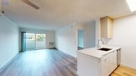This contemporary 700 square foot apartment in Newport Beach offers a harmonious blend of style and functionality. The open-plan living area is flooded with natural light from the sliding glass doors leading to a private balcony, perfect for enjoying the coastal breeze. The space boasts sleek hardwood flooring throughout, creating a seamless flow between rooms.

The kitchen is a modern marvel, featuring light-colored cabinetry, stainless steel appliances, and a practical island that doubles as a breakfast bar. The bedroom is generously sized at 180 square feet, complete with a ceiling fan and ample built-in closet space. The bathroom showcases a clean, white aesthetic with a spacious vanity and a combination shower/tub.

The apartment's design maximizes space efficiency, with clever storage solutions and an open layout that creates an airy atmosphere. The neutral color palette provides a blank canvas for personal decoration, while the quality finishes add a touch of luxury. This Newport Beach residence is ideally suited for those seeking a contemporary living space in a prime coastal location.