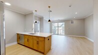 Located at 445 South Ave E in Westfield, NJ, this well-designed 2-bedroom, 2-bathroom residence offers a thoughtfully planned single-floor layout with modern finishes throughout. The heart of the home is an open-concept living, dining, and kitchen area bathed in natural light. The kitchen features a large center island with white quartz countertops, warm honey-toned cabinetry, stainless steel appliances, and stylish pendant lighting — seamlessly flowing into the dining and living areas. Light wood-toned flooring runs throughout the main living spaces, complemented by crown molding and recessed lighting that enhance the clean, contemporary aesthetic. Sliding glass doors lead to a private balcony, extending the living space outdoors. The spacious primary bedroom offers generous proportions and direct balcony access, while the second bedroom benefits from natural light through large windows. The primary bathroom includes a glass-enclosed walk-in shower, dark quartz countertops, and tile flooring. The second bathroom is elegantly finished with marble-look tile, a soaking tub with shower, white cabinetry, and built-in shelving. Three closets and a hallway provide ample storage, completing this move-in-ready residence.