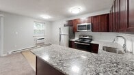 Located at 409 Easton Rd in Willow Grove, PA, this two-bedroom, one-bathroom unit offers a practical and comfortable single-floor layout. The kitchen is a standout feature, showcasing rich dark wood cabinetry, granite countertops, light hardwood-style flooring, and a full suite of stainless steel appliances including a refrigerator, range, and microwave. A peninsula counter adds additional prep space and a natural division between the kitchen and living area.

Both bedrooms are carpeted in a neutral tan tone and painted in soft gray, creating a calm and restful atmosphere. Each bedroom includes a double sliding-door closet, providing ample storage. Natural light filters in through windows, with baseboard heating and wall-mounted AC units ensuring year-round comfort. The primary bedroom offers a generous footprint, comfortably accommodating standard bedroom furniture.

The bathroom features a clean, white tub-shower combination with chrome fixtures and light hardwood-style flooring, maintaining a bright and tidy aesthetic consistent with the rest of the unit. Throughout the space, white trim and neutral gray walls create a cohesive, move-in-ready feel. This well-appointed unit combines functional design with modern finishes in a convenient Willow Grove location.