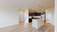 Located at 1000 New Holland Way NE in Gainesville, GA, this well-appointed 2-bedroom, 2-bathroom residence offers a thoughtfully designed single-level layout with modern finishes throughout. The open-concept kitchen and living area serves as the heart of the home, showcasing dark espresso cabinetry, granite countertops, a white subway tile backsplash, and a full suite of stainless steel appliances. A large central island with an integrated sink and pendant lighting adds both functionality and style, while light wood-style flooring flows seamlessly throughout the main living areas. The spacious primary bedroom features plush carpeting, a ceiling fan, and ample natural light from multiple windows. A generously sized walk-in closet with wire shelving provides excellent storage. The second bedroom also features soft carpeting and a ceiling fan. Both bathrooms are finished with clean, neutral tilework, including a tiled tub-shower surround in the full bath. A private balcony extends the living space outdoors, offering open views of lush greenery and the surrounding Gainesville landscape. Two dedicated closets throughout the home ensure practical storage solutions, completing this functional and attractive residence.