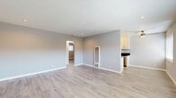 Located at 530 W Wilson St in Costa Mesa, California, this thoughtfully updated 2-bedroom, 1-bathroom single-story home offers a clean, modern aesthetic throughout. Light wood-look flooring flows seamlessly across every room, complemented by soft gray walls and crisp white trim that create a bright, cohesive atmosphere.

The open living area is spacious and airy, featuring recessed lighting and a wall-mounted heating unit, with easy sight lines into the adjoining kitchen. The galley-style kitchen is well-appointed with white shaker cabinets, dark granite countertops, black hardware accents, stainless steel appliances including a gas range and dishwasher, and a stylish geometric ceiling light fixture. A dining nook adjacent to the kitchen benefits from a large window that fills the space with natural light.

Both bedrooms are comfortably sized with neutral walls, ceiling fans, and windows dressed with white blinds. The primary bedroom features a mirrored sliding-door closet that enhances the sense of space. The full bathroom is finished with a white vanity, dark granite countertop, undermount sink, brushed nickel fixtures, and a large mirror, maintaining the home's cohesive modern style. A connecting hallway ties all rooms together efficiently, completing this well-designed Costa Mesa residence.