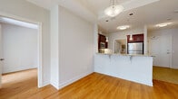 This single-floor residence offers a thoughtfully designed layout encompassing two bedrooms, two bathrooms, a combined kitchen and living area, and a hallway. Warm-toned hardwood flooring flows consistently throughout the main living spaces and bedrooms, contributing to a cohesive and inviting atmosphere.

The living room serves as a focal point of the home, anchored by an elegant fireplace with a classic white mantel and tile surround. Flanking the fireplace are two arched windows that admit generous natural light, creating a bright and welcoming environment.

The kitchen is well-equipped and features rich cherry wood cabinetry, granite countertops with a tile backsplash, and a full suite of stainless steel appliances including a refrigerator, range, microwave, and dishwasher. A peninsula with an extended granite countertop provides additional workspace and casual seating, while pendant lighting adds a polished finishing touch.

Both bedrooms are finished with the same warm hardwood flooring and neutral walls, offering functional and comfortable spaces. The primary bedroom includes a closet.

Each bathroom mirrors the kitchen's design aesthetic, with cherry wood vanities topped with granite countertops, undermount sinks, large mirrors, and tile flooring, delivering a consistent and refined finish throughout the home.