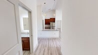 Located at 11613 Vista Terrace Way in Farragut, Tennessee, this single-floor residence offers a clean, contemporary design highlighted by soaring vaulted ceilings and a bright, neutral color palette throughout. The open-concept kitchen is a standout feature, showcasing rich dark wood cabinetry that extends to ceiling height, granite countertops, a peninsula island with a double sink, and a full suite of stainless steel appliances including a refrigerator, range, and microwave. Pendant globe lighting and a track light fixture add a modern touch overhead. Light wood-look luxury vinyl plank flooring flows through the main living areas, creating a cohesive and easy-to-maintain surface. The spacious living area benefits from dual windows that invite generous natural light and is equipped with a ceiling fan. Bedrooms feature plush neutral carpet and large windows, providing a comfortable and well-lit retreat. A full bathroom includes a granite-topped vanity with a wood cabinet base, a tub/shower combination with tiled surround, and coordinating wood-look flooring. A glass-panel door opens to a private outdoor wood deck, adding functional outdoor living space. The overall ambiance is modern, airy, and move-in ready.