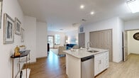 Located at 1133 West Baltimore Pike in Media, PA, this well-appointed one-bedroom, two-bathroom residence offers a thoughtfully designed single-floor layout. The open-concept kitchen is a standout feature, showcasing crisp white shaker cabinetry — including glass-front upper cabinets — granite countertops, a tile backsplash, and a full suite of stainless steel appliances including a refrigerator, range, and built-in microwave. A central kitchen island with an undermount sink and granite surface provides additional prep space and connects seamlessly to the dining area. The living room is bright and welcoming, benefiting from natural light through large windows with sheer drapery and a glass door leading to a private outdoor area. Light wood-look flooring runs throughout the main living spaces, lending a clean, modern aesthetic. The bedroom offers plush carpeting, a generous window, and ample room for a full suite of furniture. The bathrooms are finished with neutral tile flooring and granite-topped vanities; one features a glass-enclosed walk-in shower with large-format marble-style tile. A carpeted hallway connects the private areas of the residence, completing a cohesive and comfortable layout.