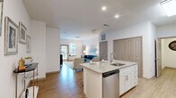 Located at 1133 West Baltimore Pike in Media, PA, this well-appointed one-bedroom, two-bathroom residence offers a thoughtfully designed single-floor layout. The open-concept kitchen is a standout feature, showcasing crisp white shaker cabinetry — including glass-front upper cabinets — granite countertops, a tile backsplash, and a full suite of stainless steel appliances including a refrigerator, range, and built-in microwave. A central kitchen island with an undermount sink and granite surface provides additional prep space and connects seamlessly to the dining area. The living room is bright and welcoming, benefiting from natural light through large windows with sheer drapery and a glass door leading to a private outdoor area. Light wood-look flooring runs throughout the main living spaces, lending a clean, modern aesthetic. The bedroom offers plush carpeting, a generous window, and ample room for a full suite of furniture. The bathrooms are finished with neutral tile flooring and granite-topped vanities; one features a glass-enclosed walk-in shower with large-format marble-style tile. A carpeted hallway connects the private areas of the residence, completing a cohesive and comfortable layout.