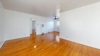 Located at 3701 Montclair St in the Jefferson Park neighborhood of Los Angeles, this single-story, one-bedroom, one-bathroom unit offers a well-organized layout across a compact but efficiently designed floor plan. Rich, warm-toned hardwood floors run throughout the main living areas and bedroom, lending a sense of continuity and warmth to the space.

The combined living and dining area is bright and open, featuring a ceiling fan with light fixture, a wall-mounted heater unit, and large windows that invite abundant natural light. Clean white walls and polished hardwood floors give the space a fresh, airy feel.

The kitchen is well-appointed with white cabinetry, a tile backsplash, stone-look tile flooring, a stainless steel double-basin sink with a matte black faucet, a gas range, and a full-size stainless steel refrigerator. A door from the kitchen provides additional access to the exterior.

The bedroom is generously proportioned, featuring its own ceiling fan, a large window with outdoor views, and a built-in storage unit with upper cabinetry. Three closets throughout the unit provide ample storage.

The bathroom features white marble-look tile flooring, a tiled vanity countertop with a matte black faucet, a window for natural light and ventilation, and a bathtub. Matte black hardware accents throughout add a modern, cohesive touch.