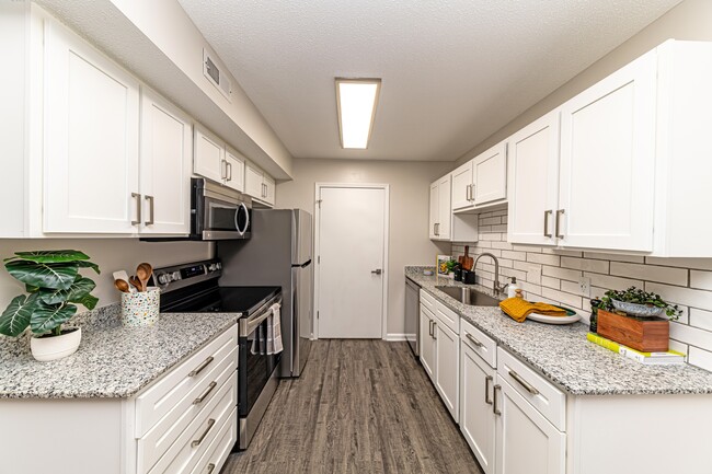 Kitchen with granite counters, modern cabinetry, and stainless steel appliances - The Alexander Apartment Homes