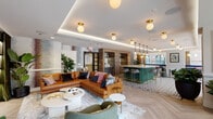 Located on W Erie Street in Chicago's vibrant River North neighborhood, this single-floor amenity lounge is designed with a refined yet approachable aesthetic that blends contemporary finishes with warm, eclectic details. The open layout is organized into several distinct zones, each serving a different purpose while maintaining a cohesive visual flow throughout the space.

The main lounge area anchors the room with rich cognac leather sofas arranged around a sculptural white coffee table. A marble-surround linear fireplace with built-in shelving and a mounted television creates a cozy focal point, complemented by abstract wall murals and lush indoor plants. Overhead, cove lighting and globe pendant fixtures in brushed brass cast a warm, inviting glow.

Adjacent to the lounge, a striking emerald green bar island with brass-trimmed bar stools serves as both a social hub and a visual centerpiece. The flooring transitions between patterned mosaic tile beneath the bar and light herringbone hardwood throughout the rest of the space, adding textural variety. A dedicated café-style seating area with marble bistro tables and dusty rose chairs lines floor-to-ceiling windows, offering expansive views of the surrounding Chicago skyline and an adjacent outdoor terrace. A compact wood-paneled kitchenette with quartz countertops and a matte black faucet provides practical utility.