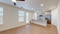 This well-designed two-story home offers 3 bedrooms and 4 bathrooms across two thoughtfully laid-out floors. The main level features an open-concept kitchen and living area bathed in natural light from multiple windows. The kitchen is appointed with gray shaker-style cabinetry, stainless steel appliances including a refrigerator, microwave, and range, as well as a granite-topped peninsula that doubles as a breakfast bar — all tied together with light wood-look flooring and recessed lighting throughout. Ceiling fans provide added comfort in both the living area and bedrooms. The upper level houses the bedrooms, each featuring plush carpeting, ceiling fans, and ample natural light from large windows with exterior views. The generously sized primary bedroom includes its own dedicated closet space, while additional closets serve the secondary bedrooms. A dedicated laundry room on the upper level comes equipped with a full-size washer and dryer and overhead gray cabinetry for extra storage. Bathrooms feature consistent gray cabinetry with brushed nickel hardware. Two hallways connect the home's spaces seamlessly, contributing to a clean, modern, and functional living environment.