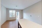 Located at 2320 Clubhouse Station Pl in Waldorf, Maryland, this well-appointed 2-bedroom, 2-bathroom residence offers a thoughtfully designed single-level floor plan with a clean, contemporary aesthetic throughout. Light hardwood-style flooring flows seamlessly across the entire unit, complementing the neutral gray and white color palette.

The open-concept kitchen, dining, and living area serves as the heart of the home. The kitchen is outfitted with white shaker-style cabinetry, a classic subway tile backsplash, white quartz countertops, a center island, and a full suite of stainless steel appliances including a French door refrigerator, electric range, built-in microwave, and dishwasher. Recessed lighting illuminates the space efficiently. The adjacent living and dining area features a private balcony door, allowing natural light to pour in and offering outdoor views.

The spacious primary bedroom includes its own en-suite bathroom, which features a dual-sink vanity with white cabinetry, a walk-in shower with white tile surround, and a large walk-in closet with wire shelving systems. The second bedroom is well-sized with its own closet. The second bathroom includes a single vanity, a tub-shower combination, and matching finishes. A dedicated laundry area and hallway with additional closet storage complete this functional and modern residence.