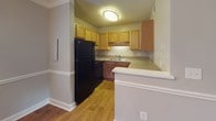 Located on Wappetaw Place in Mount Pleasant, South Carolina, this single-story home offers a practical and well-organized layout suited for comfortable everyday living. The interior is finished with a neutral gray color palette throughout, creating a cohesive and clean aesthetic across all rooms.

The living area features plush carpeting, crown molding, and tile flooring at the entry, establishing a welcoming transition into the home. A closet and direct access door are conveniently positioned near the entryway. The kitchen is equipped with warm-toned wood cabinetry, black appliances including a refrigerator and range, a double sink, and a peninsula with a white countertop that offers additional workspace and separation from adjoining areas. Hardwood flooring runs through the kitchen, adding warmth and contrast.

The bedrooms are carpeted and include ceiling fans with light fixtures, neutral walls, and built-in closets. Natural light filters through blinded windows in several rooms, offering views of the surrounding greenery. One bedroom features crown molding and a full-size closet, while others include sliding or bifold closet doors for practical storage. The bathroom is tiled and finished with a vanity and standard fixtures. Overall, the home presents a functional, move-in ready interior in a well-established Mount Pleasant neighborhood.