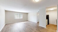 Located at 1 Lakeside Rd in Greenville, SC, this single-floor, one-bedroom, one-bathroom residence offers a well-organized layout that includes a living room, kitchen, bedroom, bathroom, hallway, and two closets. The living room is bright and open, featuring wood-look laminate flooring and a large window that allows generous natural light to fill the space. The kitchen is equipped with white cabinetry, dark granite-style countertops, a stainless steel sink, dishwasher, and a stylish mosaic tile backsplash that adds a modern touch. The bedroom is a comfortable, well-proportioned room finished with plush carpet flooring and a wide window that frames outdoor greenery, contributing to a calm and restful ambiance. Two closets provide practical storage — one features built-in shelving alongside a hanging rod, offering organized storage solutions. The bathroom includes a clean, white tub and shower unit with an accessibility grab bar. Neutral tones are used throughout, creating a cohesive, clean aesthetic. The entry area also features wood-look flooring, establishing a welcoming transition into the home. Overall, the space presents a functional and tidy layout suited for comfortable everyday living.