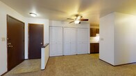 Located on Town Hall Road in Menomonee Falls, Wisconsin, this single-floor unit offers a well-organized layout designed for comfortable everyday living. The living area is generously proportioned, featuring neutral carpet, a ceiling fan with integrated lighting, and a low half-wall partition that defines the entryway. A wall of double bifold closet doors provides substantial built-in storage, while two interior doors offer access to additional rooms. The open sightline from the living area extends toward the kitchen, creating a connected feel throughout the common spaces.

The galley-style kitchen is efficiently designed, featuring dark wood cabinetry on both upper and lower levels, a double-basin sink, white appliances including a gas range and full-size refrigerator, and durable tile flooring. The layout maximizes usable counter and storage space within a compact footprint.

Both bedrooms are carpeted and well-lit by large windows dressed with vertical blinds, allowing natural light to filter in. Each room includes baseboard heating and offers a calm, neutral backdrop. The full bathroom is finished with tile flooring, a white vanity with drawers, a mirrored medicine cabinet, and a tub/shower combination equipped with grab bars for added accessibility.