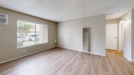 Located at 5351 47th Ave in Sacramento, CA, this one-bedroom, one-bathroom unit offers a practical and efficient single-floor layout. Throughout the space, light wood-style flooring provides a clean, cohesive look, complemented by neutral beige walls and textured ceilings.

The combined kitchen and living room area forms the heart of the unit. The kitchen features white cabinetry, light countertops, a sink with a dishwasher, and a full-size refrigerator, all supported by warm overhead lighting. The open connection to the living area allows for flexible use of the shared space, which also includes a wall-mounted heating unit.

The living room receives natural light through a window with horizontal blinds that offers views of the surrounding outdoor area. A wall-mounted air conditioning unit ensures year-round climate comfort. The entry door opens directly into this space, providing a straightforward and accessible layout.

The bedroom is generously sized, featuring the same wood-style flooring and a window that brings in natural light. A dedicated closet adds practical storage. The full bathroom includes a combined tub and shower, a toilet, and a vanity with a light countertop and white cabinetry. Clean chrome fixtures complete the space with a simple, functional aesthetic throughout.