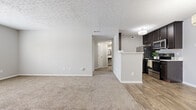 Located at 1038 Bayridge Dr in Lewis Center, Ohio, this one-bedroom, one-bathroom residence offers a thoughtfully designed single-floor layout that maximizes functionality and comfort. The open-concept living and kitchen area serves as the heart of the home, where wood-style plank flooring flows seamlessly through the kitchen into the living space. The kitchen is well-appointed with dark espresso cabinetry, stainless steel appliances including a range, microwave, and refrigerator, complemented by a tile backsplash and a convenient peninsula that separates the cooking area from the living room. The living room features neutral carpeting, a textured ceiling, and a paneled front entry door that welcomes natural light. A hallway connects the main living area to the private bedroom and bathroom. The spacious primary bedroom is carpeted and bathed in natural light through a window fitted with blinds, offering a calm and comfortable retreat. The full bathroom features wood-style flooring, a full-sized soaking tub with a shower, a toilet, and dark cabinetry above for ample storage. A dedicated closet and hallway complete the layout, providing practical storage solutions throughout. The unit's neutral color palette and clean finishes create a move-in-ready environment suited for comfortable everyday living.