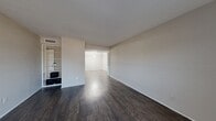 Located at 2100 Tannehill Dr in Houston's Heights neighborhood, this 2-bedroom, 1-bathroom unit offers a well-organized single-floor layout. The living room is a highlight of the space, featuring rich dark hardwood-style flooring, neutral-toned walls, and built-in open shelving that adds both functionality and character. The space flows naturally into the hallways, creating a connected and accessible feel throughout.

The galley-style kitchen is efficiently designed with white cabinetry lining both sides, light granite-style countertops, and black appliances including a range, refrigerator, and dishwasher. A flush ceiling light keeps the kitchen bright and practical.

Both bedrooms are finished with plush carpet and ceiling fans for comfort. The primary bedroom offers a generous footprint, while the second bedroom includes a window that invites natural light and outdoor views. Each bedroom has access to closet space, with open shelving storage visible in the living area as well.

The bathroom is clean and functional, featuring a full tub-shower combo with white tile surround, toilet, and vanity with a stone-style countertop. Wood-look flooring in the bathroom ties in with the rest of the unit's design palette. Overall, the unit presents a practical and cohesive living environment in a convenient Houston location.