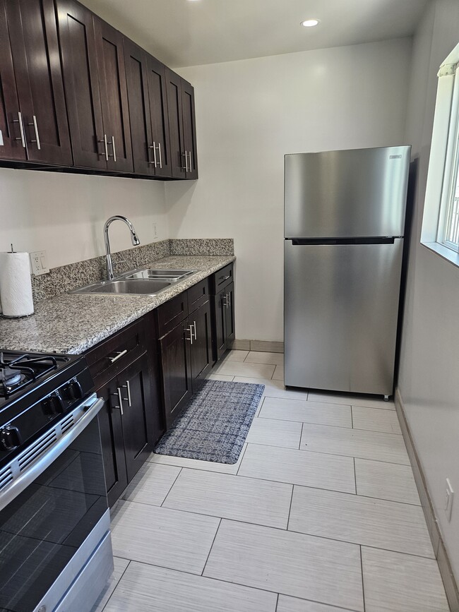 Full Kitchen with new 18 cubic refrigerator and lots of storage with window - 6043 Romaine St