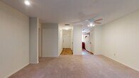 This single-floor, 2-bedroom, 2-bathroom residence offers a practical and comfortable layout with a thoughtful mix of flooring materials throughout. The entryway features warm hardwood floors that extend into the kitchen and bathrooms, while plush carpet covers the living areas and bedrooms.

The living room is generously sized, equipped with a ceiling fan, and bathed in natural light from large windows and a sliding glass door that opens to a view of lush outdoor greenery. The adjoining kitchen is designed in a U-shaped configuration, offering ample cabinetry in rich wood tones, light countertops, and white appliances including a range and dishwasher. A window above the sink brings in additional natural light.

Both bedrooms are carpeted and feature ceiling fans and windows with outdoor views, creating bright and airy retreats. The two bathrooms are clean and functional — one features a tub/shower combination with a wood-vanity and hardwood floors, while the second bathroom is conveniently accessible from the bedroom hallway and shares a similar design aesthetic.

A central hallway connects the main living spaces, providing a logical and efficient flow throughout the home. Overall, this residence offers a comfortable, move-in-ready layout suited for a variety of lifestyles.
