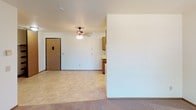 Located at 3600 S Golden Creek in Sioux Falls, South Dakota, this single-floor unit offers a practical and comfortable layout suited for everyday living. The living area is finished with wall-to-wall carpeting and features a textured ceiling, baseboard heating, and a wall-mounted air conditioning unit. A sliding glass door opens directly to a private balcony, allowing natural light to fill the space and providing an outdoor retreat. The entry area transitions smoothly between the tiled and carpeted zones, with a ceiling fan overhead adding comfort and airflow throughout. The kitchen is efficiently designed with warm wood cabinetry, light countertops, a stainless steel sink, and white appliances including a range and refrigerator. Tile flooring and overhead lighting complete the functional cooking space. The bedroom is a quiet, carpeted room with a large window framed by views of mature trees, offering a serene and naturally lit atmosphere along with baseboard heating for year-round comfort. The bathroom is clean and straightforward, featuring a combined tub and shower unit, a toilet, and chrome fixtures. Overall, this unit presents a well-organized, single-level living space with consistent finishes and practical amenities throughout.