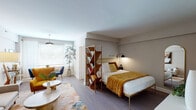 This thoughtfully designed studio showcases a mid-century modern aesthetic throughout its single floor, blending warm tones, clean lines, and functional layout to maximize every inch of space. The open main area is anchored by a cozy living zone featuring a neutral sofa, a bold mustard accent chair, a marble-top coffee table, and a colorful area rug that ties the warm and cool tones together. A freestanding angular bookshelf serves as a stylish room divider, naturally separating the sleeping area from the living space without closing it off. The sleeping area accommodates a full-sized bed with a gold metal frame, complemented by wall-mounted reading sconces and an arched full-length mirror that adds depth to the room. A compact dining nook with a round wood table and deep teal chairs sits adjacent to the living area near a window, while a gold-framed glass desk tucked into a corner creates a dedicated workspace. The kitchen is efficiently appointed with white cabinetry, a gas range, stainless steel appliances, a deep single-basin sink with a matte black faucet, and a striking geometric blue tile backsplash. The bathroom features classic white subway tile, a tub-shower combination, a pedestal sink, and white tile flooring. Natural light filters in through multiple windows, enhancing the warm, inviting ambiance throughout.