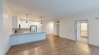 Located at 7071 Helm St in Whitestown, Indiana, this single-story, 3-bedroom, 1-bathroom home delivers a clean, modern aesthetic throughout its well-designed floor plan. The open-concept kitchen and living area serves as the heart of the home, featuring crisp white shaker cabinetry, a light quartz-topped island with an undermount sink, stainless steel appliances including a refrigerator, range, and microwave, and stylish pendant lighting. Wood-look flooring flows through the main living areas, adding warmth and continuity. The living room is bright and airy, benefiting from large windows with outdoor views and a private exterior door providing direct access to the outside. Three bedrooms offer comfortable accommodations, with the spacious primary bedroom featuring its own dedicated closet with wire shelving. Additional bedrooms are finished with neutral carpet and natural light from well-positioned windows. Three closets total provide generous storage throughout. The bathroom is neatly appointed with white subway tile surrounding a tub-shower combination, a white vanity with undermount sink, and wood-look flooring that ties the space together. A central hallway connects the bedrooms efficiently, rounding out this well-organized and move-in-ready home.