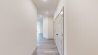 This well-appointed 2-bedroom, 2-bathroom residence offers a thoughtfully designed single-floor layout that maximizes comfort and functionality. Light-toned luxury vinyl plank flooring runs throughout the entire space, creating a cohesive and contemporary aesthetic.

The open-concept kitchen and living area serves as the heart of the home. The kitchen is outfitted with two-tone cabinetry — soft grey uppers paired with sage green lowers — complemented by a blue subway tile backsplash, a large white quartz waterfall island with an undermount sink, pendant lighting, and a full suite of stainless steel appliances including a refrigerator with ice maker, range, and microwave.

The primary bedroom is a well-sized retreat filled with natural light from multiple windows and equipped with a ceiling fan. It connects to a dedicated walk-in closet featuring wire shelving. The second bedroom is equally bright, with tall windows that invite outdoor views and a ceiling fan overhead.

The hallway is clean and modern, lined with paneled doors accented by matte black hardware. The bathroom features floor-to-ceiling grey subway tile in the tub/shower surround, a soaking tub, and matte black fixtures throughout, adding a refined contrast to the crisp white walls and light tile floors.