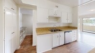 Located at 14400 Addison St, Unit 315 in Sherman Oaks, Los Angeles, this one-bedroom, one-bathroom residence offers a well-designed single-floor layout with a bright, open feel throughout. The living area is generously sized, featuring warm hardwood-style flooring and large sliding glass doors that open onto a private balcony with open views of the surrounding neighborhood and tree canopy, allowing abundant natural light to fill the space. A pass-through counter connects the living area to the kitchen, which is appointed with white cabinetry, granite-style countertops, a stainless steel double sink, and a dishwasher, complemented by wood-style flooring. The entry foyer features the same hardwood-style flooring and a mirrored sliding closet for added storage. The bedroom is carpeted for comfort and includes a wide window with outdoor views, along with a closet with sliding doors. The full bathroom is well-appointed with a dual-sink vanity featuring a wide mirror, a soaking bathtub with tile surround, and chrome fixtures. The unit also includes access to an on-site covered parking area, adding everyday convenience in this desirable Los Angeles neighborhood.