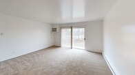 Located at 3372 Van Horn Rd in Trenton, Michigan, this one-bedroom, one-bathroom unit offers a well-utilized, single-floor layout designed for comfortable everyday living. The open-concept main area seamlessly connects the living room, dining space, and kitchen, creating a cohesive and functional flow throughout. The living room features neutral carpet flooring, a ceiling fan, a wall-mounted air conditioning unit, and a sliding glass door that opens to a private balcony with outdoor views of surrounding greenery. Baseboard heating runs along the perimeter, ensuring year-round comfort. The galley-style kitchen is efficiently arranged with dark wood cabinetry on both sides, light granite-style countertops, a stainless sink, and white appliances including a range and refrigerator, all set atop durable hardwood-style flooring. The spacious primary bedroom is carpeted and bright, featuring a large window with vertical blinds, a ceiling fan, and two louvered closet doors offering generous storage. The bathroom includes a wide vanity with dual sinks, granite-style countertops, dark wood cabinetry, and mirrored medicine cabinets. Throughout the unit, four closets provide exceptional storage capacity. The clean, neutral palette and practical layout make this a functional and inviting space.