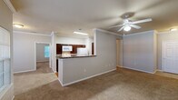 Located at 6795 Belle Vale Dr in Addis, Louisiana, this single-story, 2-bedroom, 2-bathroom home offers a functional and comfortable layout with thoughtful finishes throughout. The open-concept living and dining area is finished with plush wall-to-wall carpeting, crown molding, and a ceiling fan, creating a warm and inviting atmosphere. Natural light flows in through multiple windows, enhancing the sense of space.

The kitchen is a standout feature, boasting rich dark wood cabinetry, granite-look countertops, a double stainless steel sink, and a peninsula with bar-height seating that opens to the living area. Wood-look flooring, recessed lighting, and white appliances complete the kitchen's practical yet attractive design.

The primary bedroom is generously sized, accented with crown molding and a ceiling fan, and includes access to a spacious walk-in closet equipped with multi-level wire shelving. A second bedroom also features carpeted flooring, a ceiling fan, and its own walk-in closet with wire shelving systems.

Both bathrooms are finished with wood-look flooring and dark wood vanities with light countertops. One bathroom features a tub-shower combo, while the second is designed with accessibility in mind, including a floating vanity and grab bars. A connecting hallway ties all rooms together efficiently.