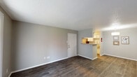 This 1-bedroom, 1-bathroom unit in Beaumont, Texas offers a well-organized single-floor layout designed for comfortable everyday living. The open living area is finished with durable wood-style flooring in a rich dark tone, neutral gray walls, and a textured ceiling that adds subtle character throughout. A sliding glass door fitted with vertical blinds leads to a private patio, allowing natural light to fill the space.

The kitchen is accessible via a pass-through counter with a tile backsplash, providing a functional connection to the living area. The galley-style kitchen is equipped with white cabinetry featuring modern hardware, a stainless steel refrigerator, an electric range, and ample counter space, making efficient use of the available area.

The bedroom is a comfortable retreat, carpeted for warmth and outfitted with a ceiling fan with integrated lighting. A window with blinds brings in natural light, and a walk-in closet provides generous storage.

The full bathroom is finished with a granite-style countertop, a framed mirror, and a tub-shower combination. Throughout the unit, the consistent use of neutral tones and updated finishes creates a cohesive and move-in-ready living environment suited for individuals or couples.