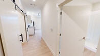 Located at 10865 Parkside Dr in Knoxville, Tennessee, this thoughtfully designed one-bedroom, one-bathroom residence offers a clean, modern aesthetic throughout its efficiently utilized single floor. Light wood-tone flooring flows seamlessly across every room, creating a bright and cohesive atmosphere.

The open living area is bathed in natural light from large windows and a set of glass French doors that lead to a private balcony, offering views of the surrounding landscape. Recessed lighting enhances the airy feel of the space. A ceiling fan adds both function and style to the living area.

The kitchen is outfitted with white cabinetry, open shelving, a stainless steel refrigerator, dishwasher, and range, complemented by a subway tile backsplash and a single-basin sink — a practical yet polished layout.

A hallway with a distinctive sliding barn door connects the living areas to the private quarters. The bedroom is a comfortably sized retreat featuring a large window with natural views, crown molding, and direct access to a dedicated walk-in closet with built-in shelving.

The bathroom features a white vanity with under-cabinet storage, a large mirror, and a glass-enclosed walk-in shower, all finished with light, neutral tones that reinforce the home's clean and contemporary character.