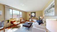 Located at Yosemite Circle in Golden Valley, MN, this two-bedroom, one-bathroom residence offers a thoughtfully arranged single-floor layout filled with natural light. The spacious living room features warm neutral walls, hardwood-style flooring, and large windows that invite abundant sunlight and outdoor views of the surrounding greenery. The open sightline flows seamlessly into the dining area, creating a connected and functional living space.

The galley-style kitchen is well-equipped with rich cherry wood cabinetry, granite-look countertops, a double stainless steel sink, and full appliance suite including an electric range and refrigerator. Light hardwood flooring adds warmth to the kitchen and dining areas.

The primary bedroom is generously sized, featuring plush carpeting, a wide window with pleasant outdoor views, and an expansive set of louvered bi-fold closet doors offering substantial storage. The second bedroom also features carpet flooring and convenient hallway access. Two additional hallway closets provide further storage throughout.

The bathroom is finished with classic white tile wainscoting, a mosaic tile floor, a tub-shower combination, and a vanity with an undermount sink. Connecting hallways with multiple closets complete this well-organized and comfortable home.
