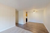 Located in Edmonds, WA, this single-level unit offers three bedrooms, one bathroom, and a practical, well-organized layout. The open living area features durable hardwood-style flooring and a ceiling fan with light fixture, creating a bright and comfortable atmosphere. A half-wall partition separates the living space from the kitchen, which is equipped with warm wood cabinetry, granite-look countertops, and dark appliances. The transition from hard flooring to plush carpet marks the shift into the bedroom wing, accessed via a central hallway. Each bedroom is carpeted and finished with neutral tones, offering a calm and restful environment. Two of the bedrooms feature sliding-door closets with built-in hanging rods, while windows throughout provide natural light and views of surrounding foliage. The primary bedroom offers a generous footprint with ample space for furnishings. The full bathroom includes a shower/tub combo with white surround, wood-toned vanity with a granite-style countertop, and hardwood-style flooring. Clean white trim, textured walls, and a consistently neutral color palette lend the space a cohesive and move-in-ready feel throughout.