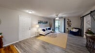 Located at 4035 Kessler Ave in Garden City, Georgia, this single-floor residence offers a thoughtfully designed layout with a cohesive, contemporary aesthetic throughout. The kitchen is outfitted with crisp white shaker cabinetry, granite-look countertops, a dark subway tile backsplash, and black appliances including a range and over-the-range microwave, complemented by gold-accented fixtures that add a touch of warmth. A breakfast bar with counter seating connects the kitchen to the dining area, which features wood-look flooring and wainscoting detail, providing an inviting space for meals and gatherings. The living room is bright and open, with durable wood-look flooring, a ceiling fan, and sliding glass doors that allow natural light to flow in and provide access to an outdoor area. The bedrooms are carpeted for comfort, each featuring ceiling fans with lighting. The primary bedroom offers ample space with room for a full furniture suite. A secondary bedroom serves well as a flexible home office, complete with a window for natural light and a closet. The bathroom presents granite-top vanity cabinetry, warm-toned walls, and wood-look flooring, maintaining the home's consistent design language. Overall, the residence combines functional layout with modern finishes for comfortable everyday living.