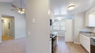 Located at 2519 Buffalo Church Rd in Sanford, NC, this single-floor, 3-bedroom, 2-bathroom home offers a well-designed layout across a comfortable footprint. The open-concept living, dining, and kitchen area serves as the heart of the home, featuring hardwood-style flooring, ceiling fans, and large windows that invite generous natural light. The kitchen is equipped with white cabinetry, granite-style countertops, black appliances including a refrigerator, range, and built-in microwave, all complemented by a clean, functional layout. The primary bedroom stands out with dramatic vaulted ceilings and multiple large windows that frame outdoor views, creating a bright and airy retreat. The two additional bedrooms are carpeted and feature textured ceilings and dedicated closets, offering practical storage. Both bathrooms are finished in a clean, neutral palette with white vanities, tub-shower combinations, and hardwood-style flooring. The home also includes a dedicated laundry area, a connecting hallway, and an impressive six closets throughout, ensuring ample storage. The consistent light gray walls, neutral tones, and mix of carpet and hard-surface flooring create a cohesive and welcoming ambiance throughout.