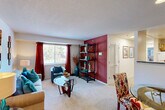 Located at 1127 Ivy Club Ln in Hyattsville, MD, this 2-bedroom, 1-bathroom residence is thoughtfully laid out across a single floor. The combined living and dining area serves as the heart of the home, featuring plush wall-to-wall carpeting, a textured ceiling, and a large window that invites natural light and outdoor greenery views. A bold accent wall adds a striking focal point to the living space, which flows seamlessly into the dining area. The kitchen is outfitted with light wood cabinetry, dark granite-style countertops, tile flooring, and white appliances including a range, over-the-range microwave, and refrigerator — providing ample storage and counter space. Both bedrooms are carpeted and offer a calm, neutral palette, with the primary bedroom featuring access to a walk-in closet with wire shelving for generous storage. A second closet provides additional organization options. The full bathroom includes a shower-tub combination and a vanity with cabinet storage. A dedicated laundry area and a connecting hallway round out the functional layout of this well-organized residence.